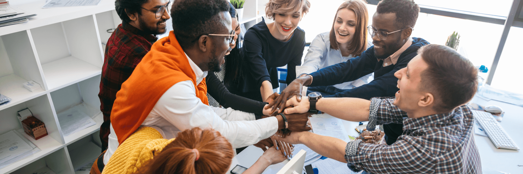 happy team of different nationalities holding hands together, non profit organization concept of working together as a team with business solutions like managed print services