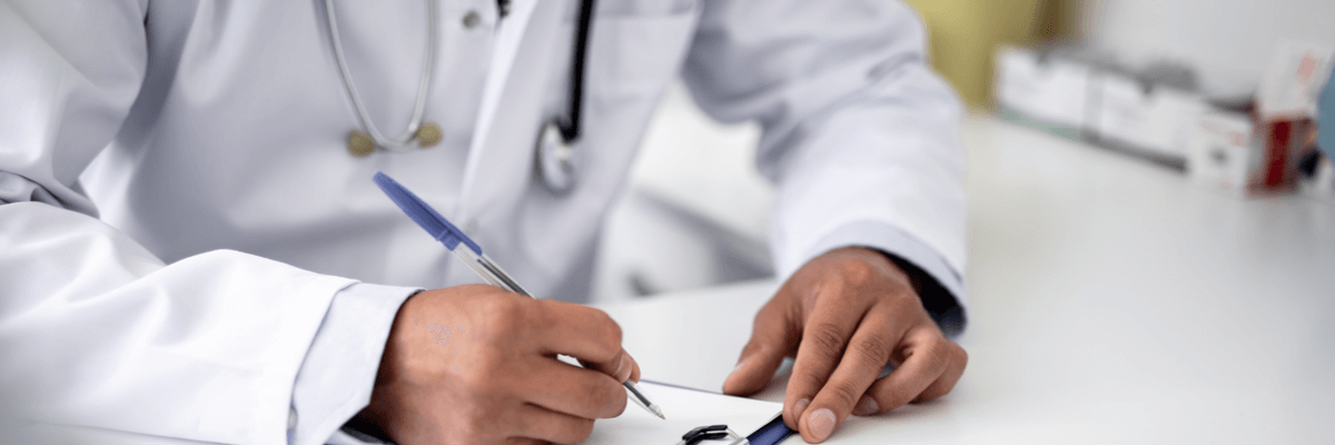 Close up of male hand holding blue pen and making notes on clipboard, doctor writing on clipboard wearing stethoscope around neck, medical or healthcare industry concept