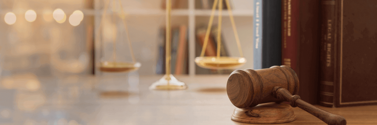 Judge gavel, law books, and scales of justice on a desk