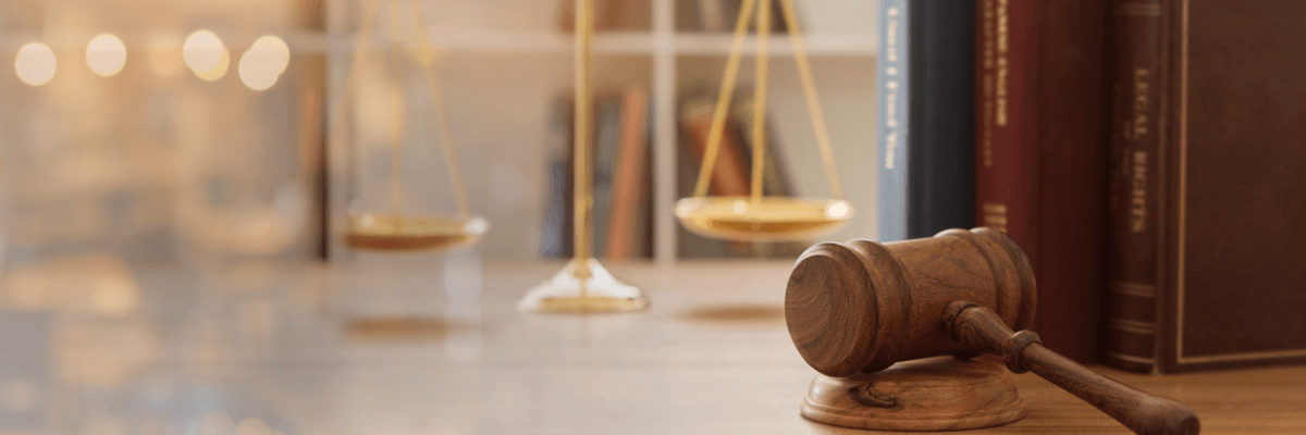 Judge gavel, law books, and scales of justice on a desk, legal institution or law firm industry
