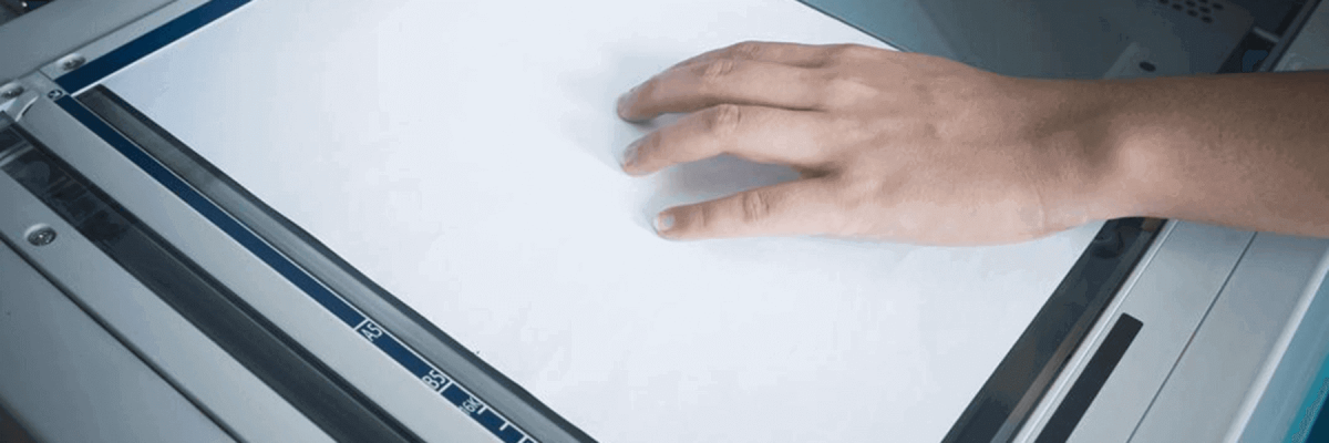 close up of a hand using a copier