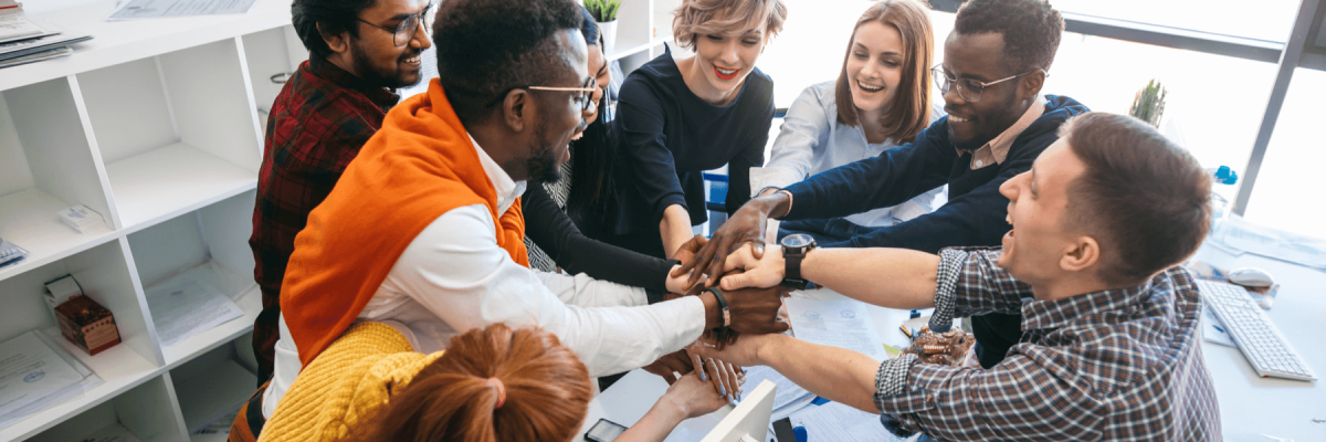 happy team of different nationalities holding hands together, non profit organization concept of working together as a team with business solutions like managed print services