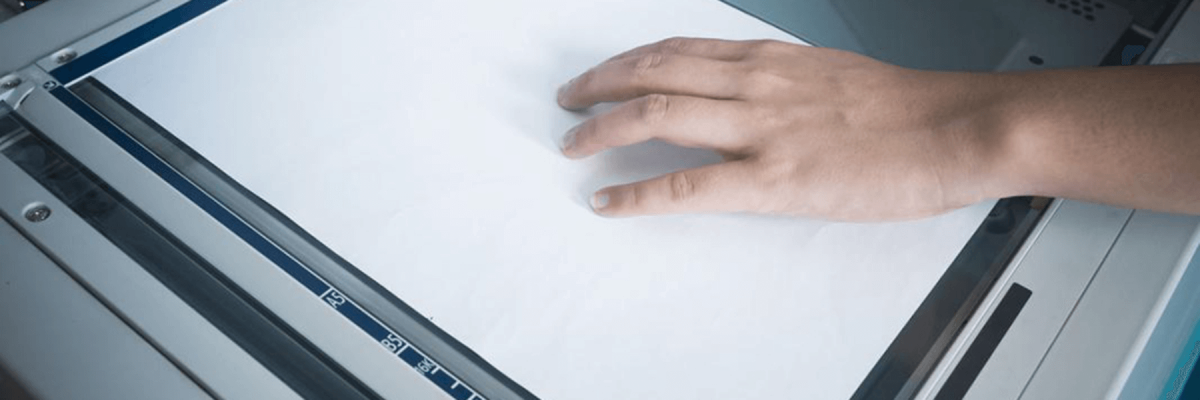 close up of a hand holding a document on top of a copy machine, copier, document capture technology, office equipment