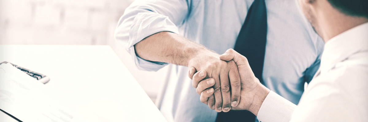 Close up of two businessmen shaking hands at the end or beginning of a meeting